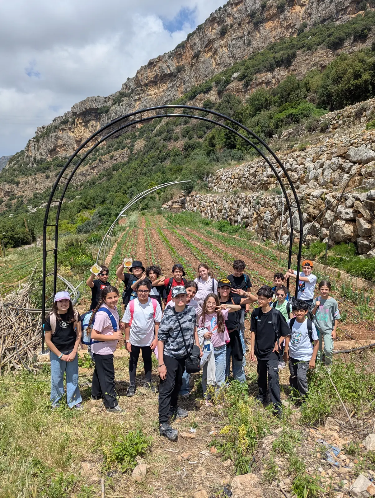 Students standing in front of the Sannour Farm arch